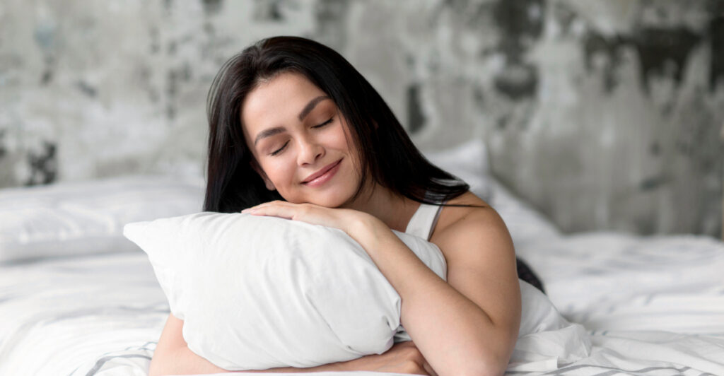 mulher deitada na cama e satisfeita com seu travesseiro limpo e sem machas